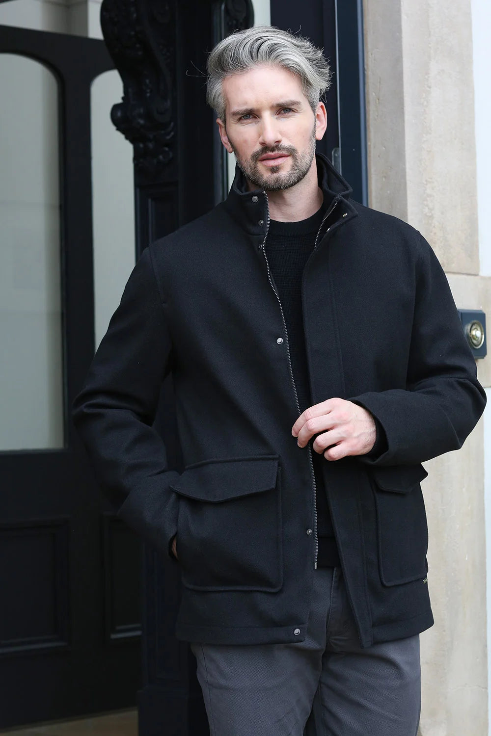 Kenrow Huxley Coat in black worn by model, front view with hands in pockets