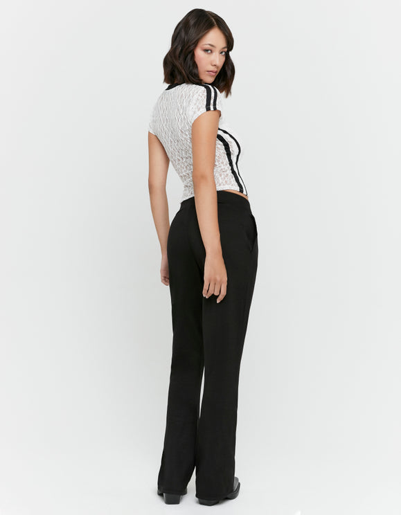 Tally Weijl black flared trousers worn by a model in a back view with a white lace top