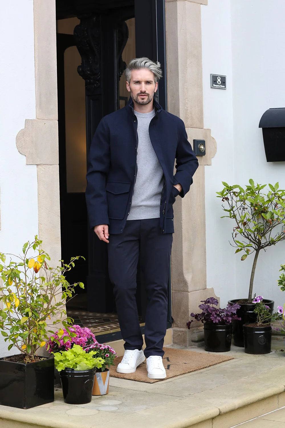 Kenrow Huxley Coat in navy worn by a model, full - length front view with hands in pockets