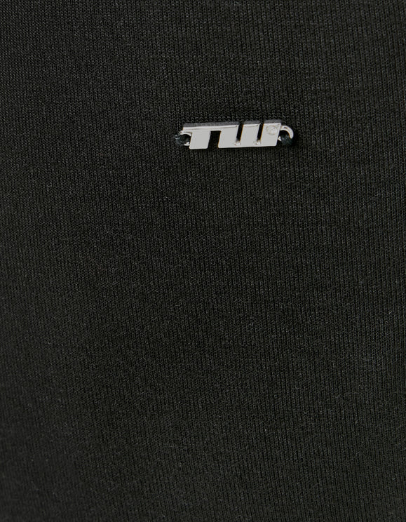 Close - up detail of the Tally Weijl metal logo on black fabric