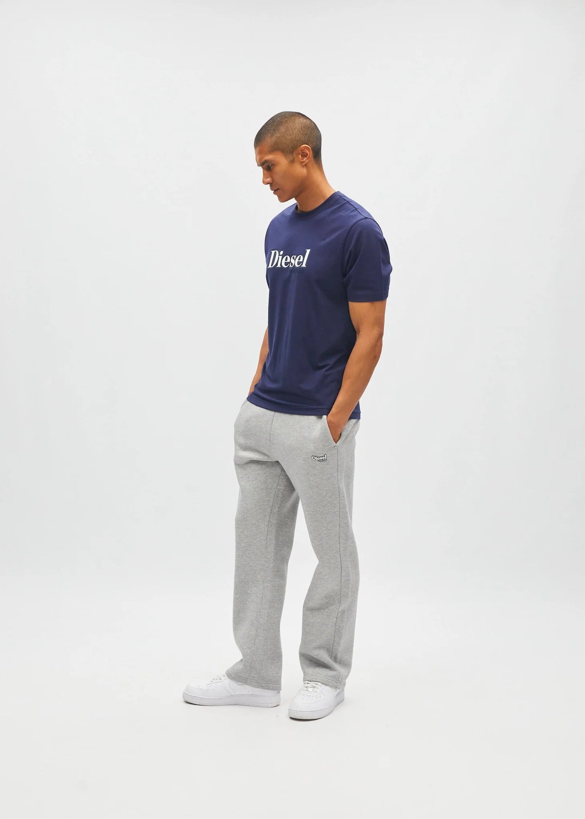 Diesel Walter Tee in navy worn by a model, side view with white Diesel logo across the chest.