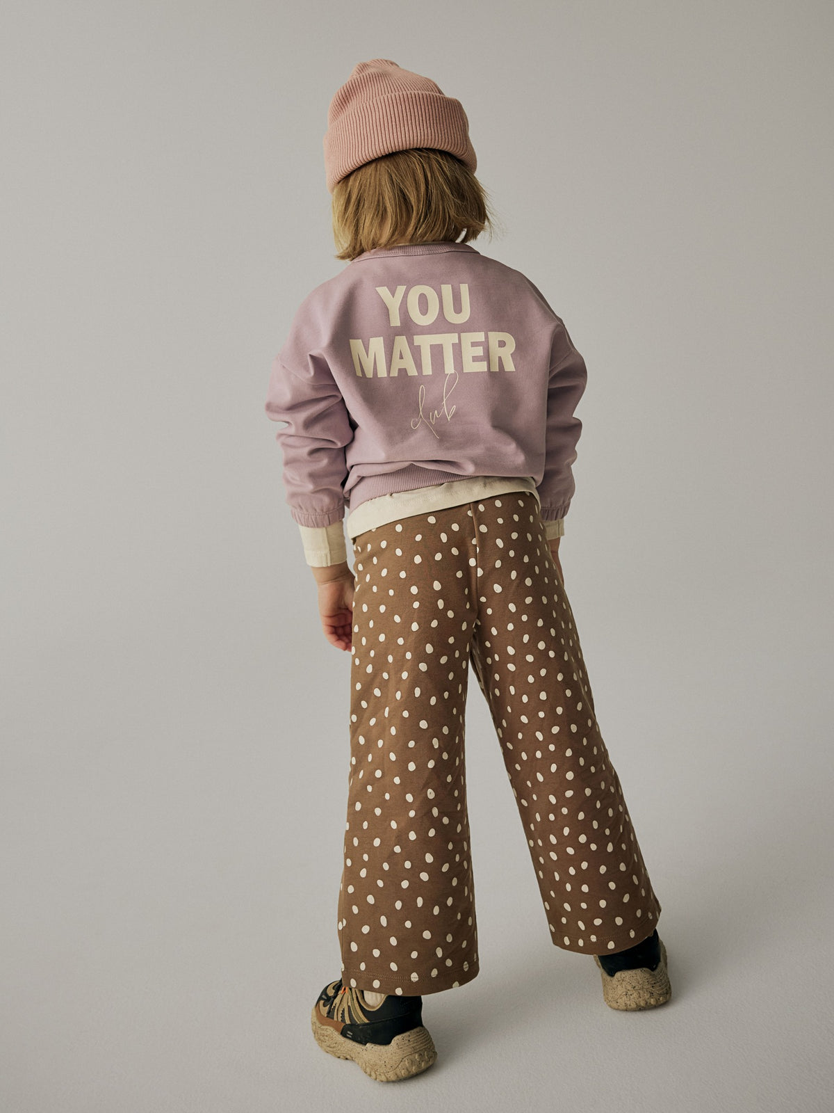 Back view of a model wearing NAME IT Rammie wide-leg dot-print sweatpants in Coca Mocha