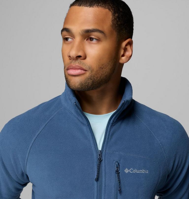 Man wearing a blue Columbia jacket against a gray background