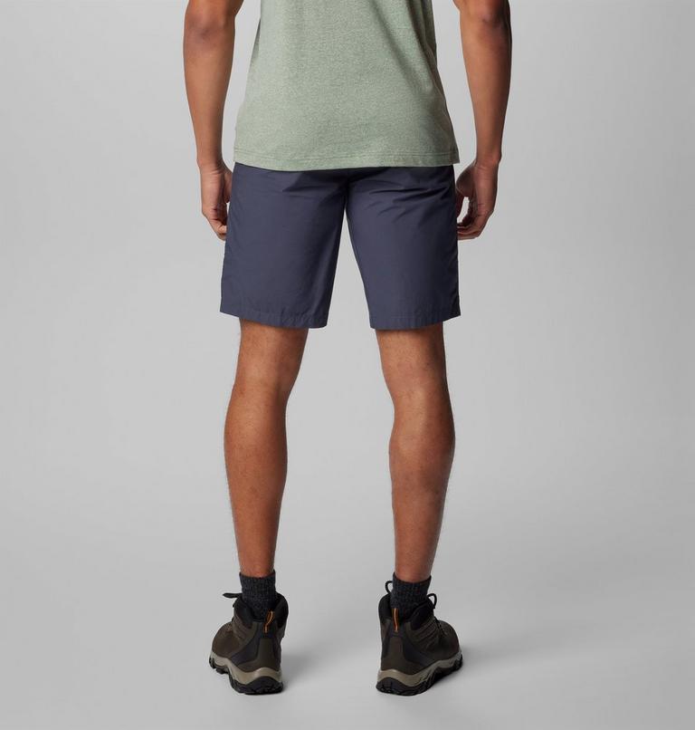Person wearing navy shorts on a plain background