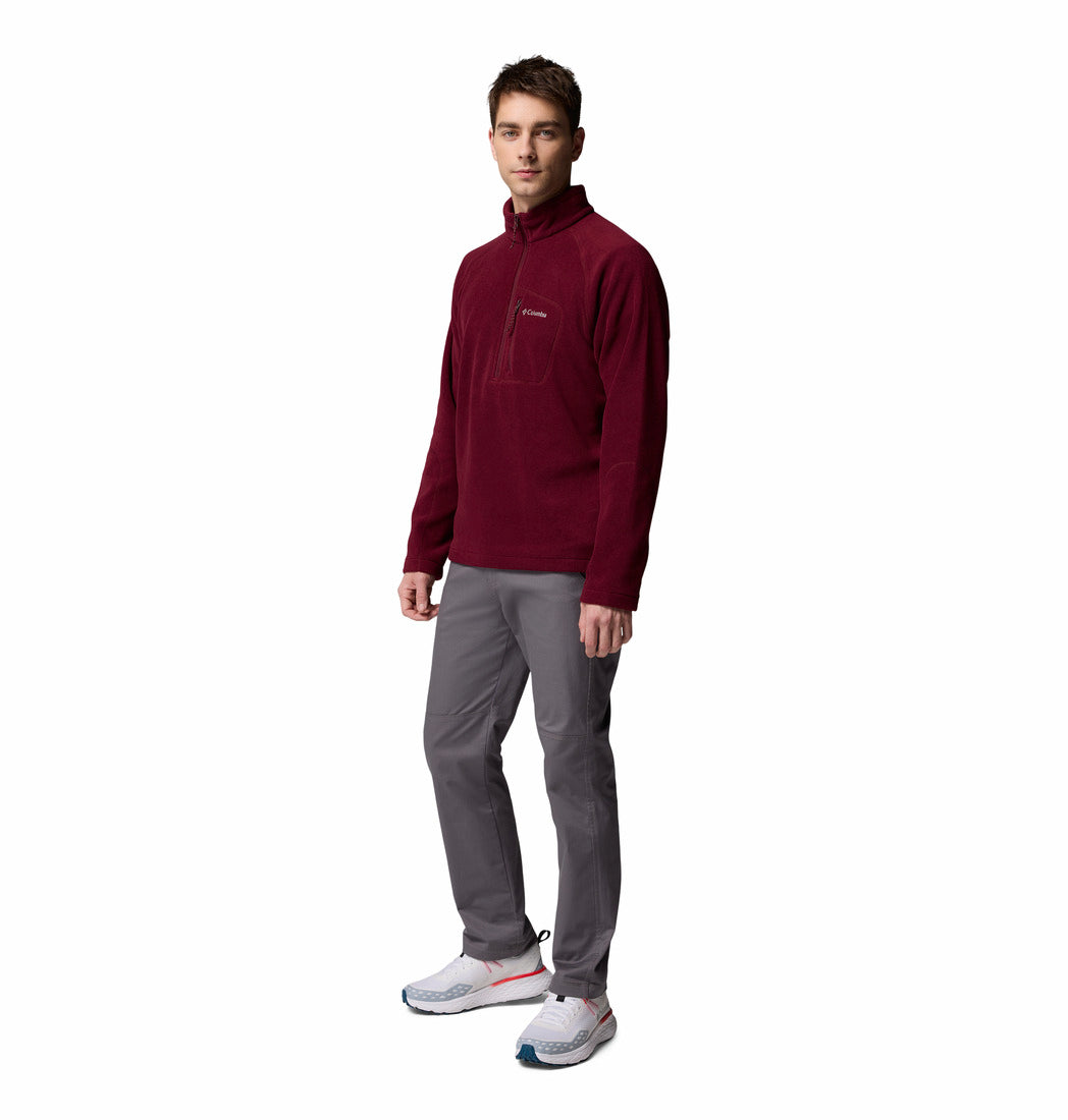 Man wearing a maroon pullover fleece and gray pants on a white background