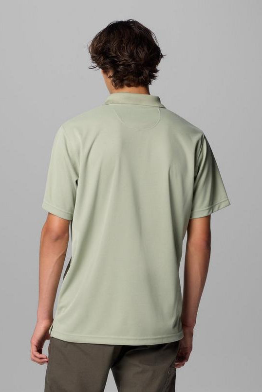Person wearing a light green polo shirt on a gray background