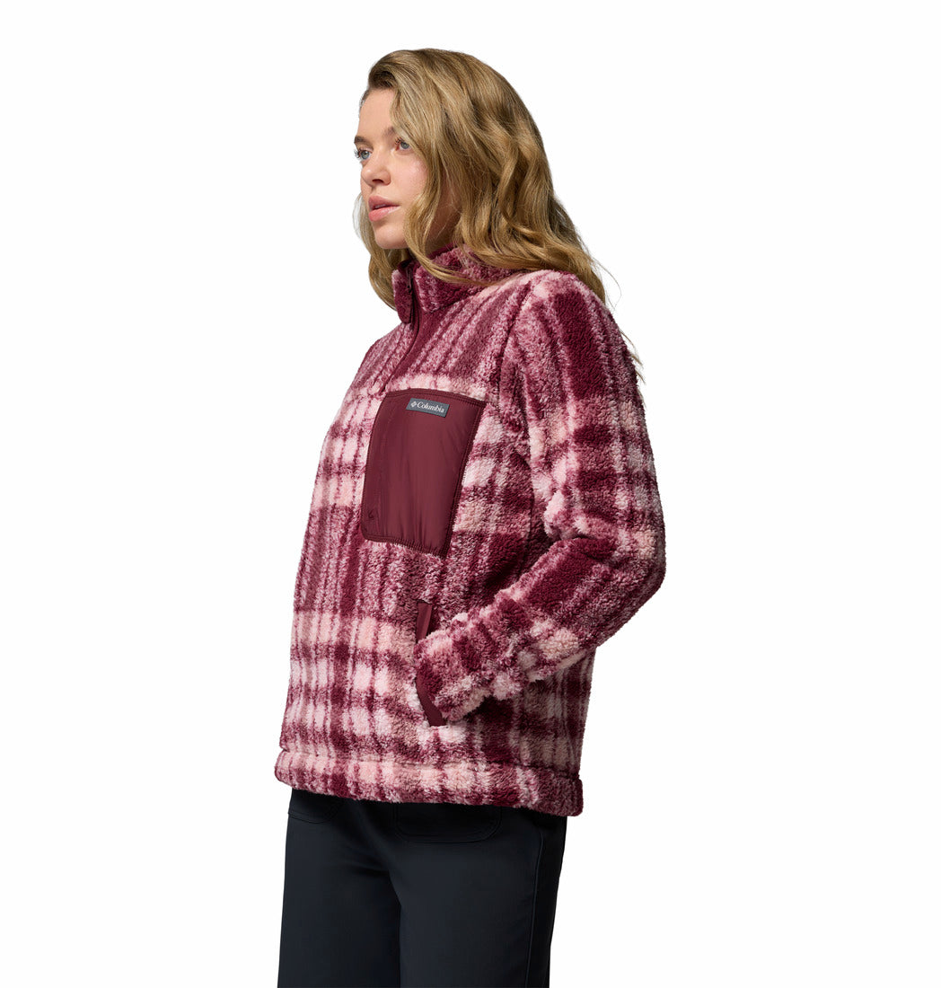 Woman wearing a plaid pullover with a visible brand logo on a white background