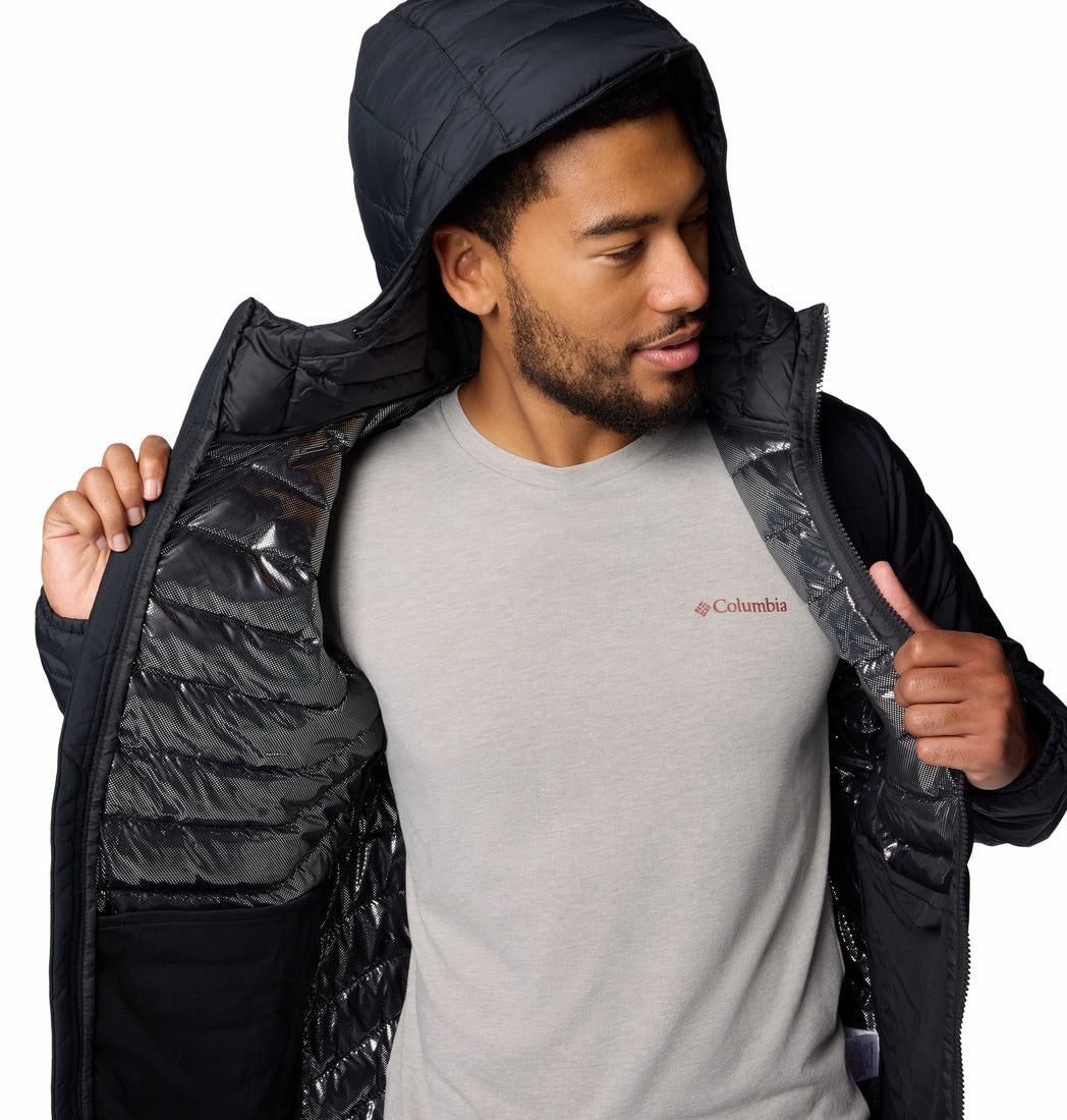 Man wearing a black puffer jacket over a gray Columbia shirt on a white background