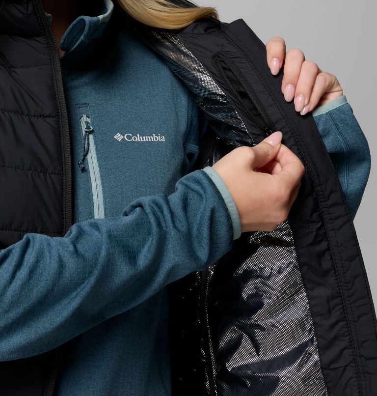 Person wearing a black Columbia gilet with a close-up of the brand logo.