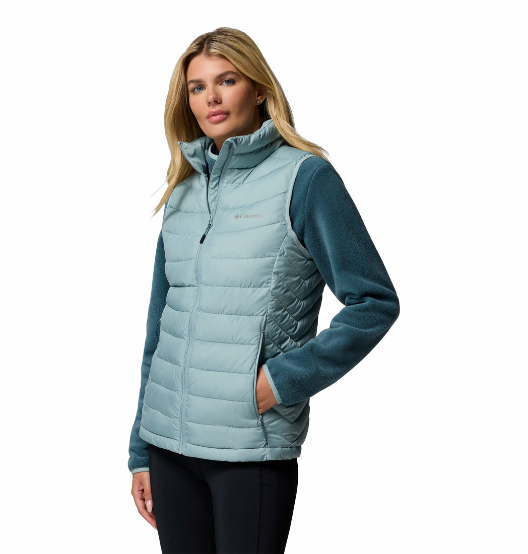 Woman wearing a light blue puffer vest on a white background