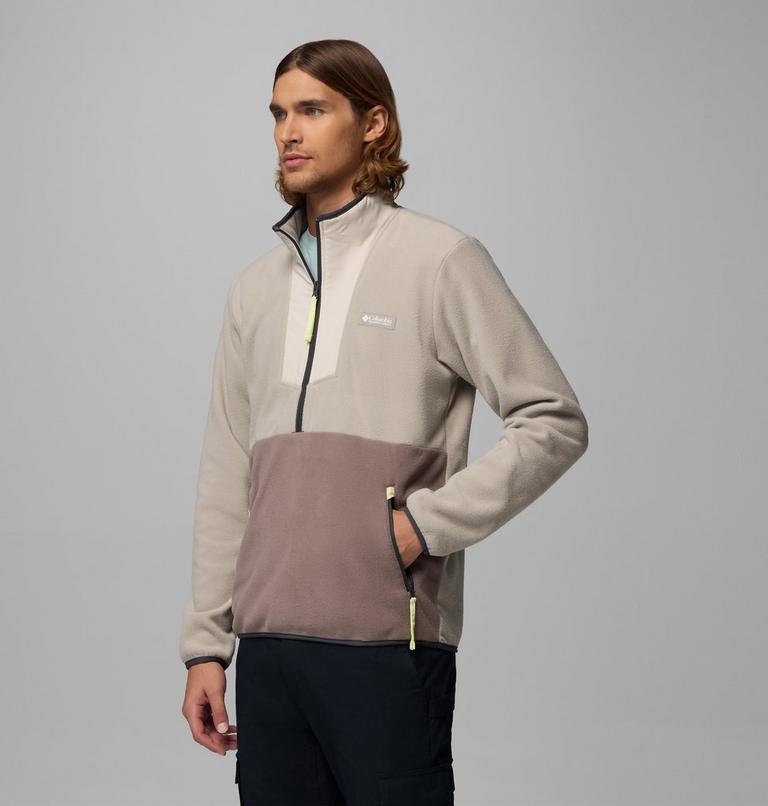 Man wearing a two-tone jacket with a gray and brown design on a gray background