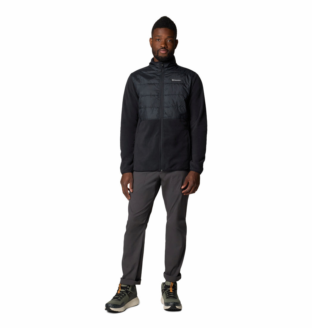 Man wearing a black fleece and pants on a white background
