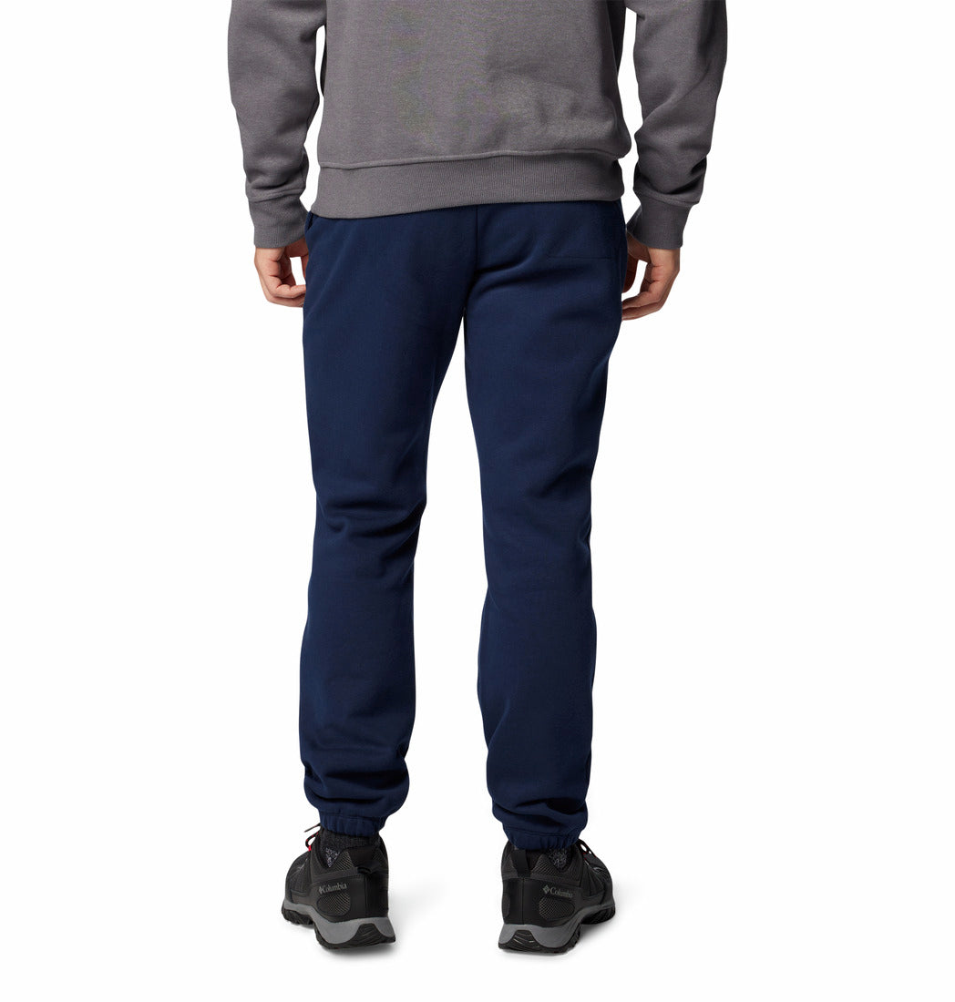 Person wearing a gray sweatshirt and navy blue pants on a white background