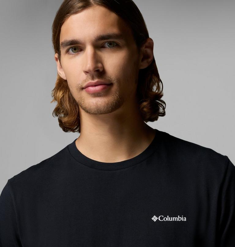 Man wearing a black Columbia t-shirt against a gray background