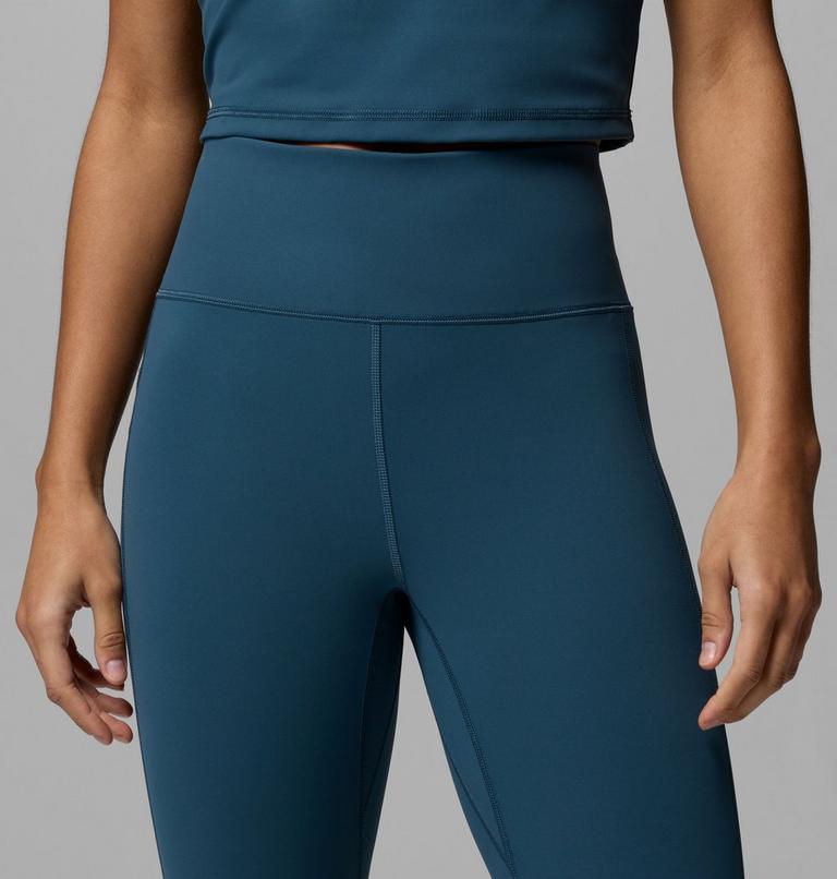 Teal athletic top and leggings on a person against a gray background