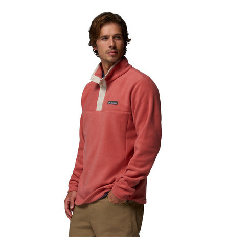 Man wearing a pink fleece pullover with a brand logo on a white background
