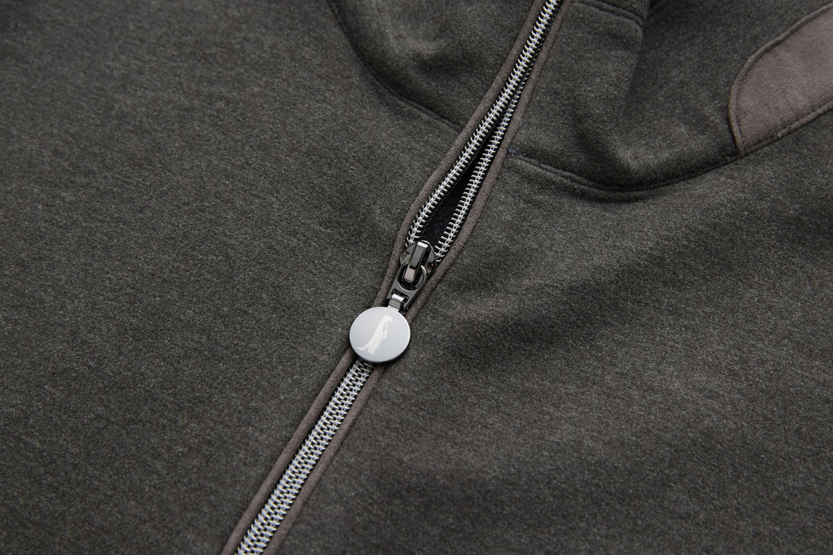 Detail of the 6th Sense peat sweat's zip fastening and round metal pull bearing the 6th Sense logo.
