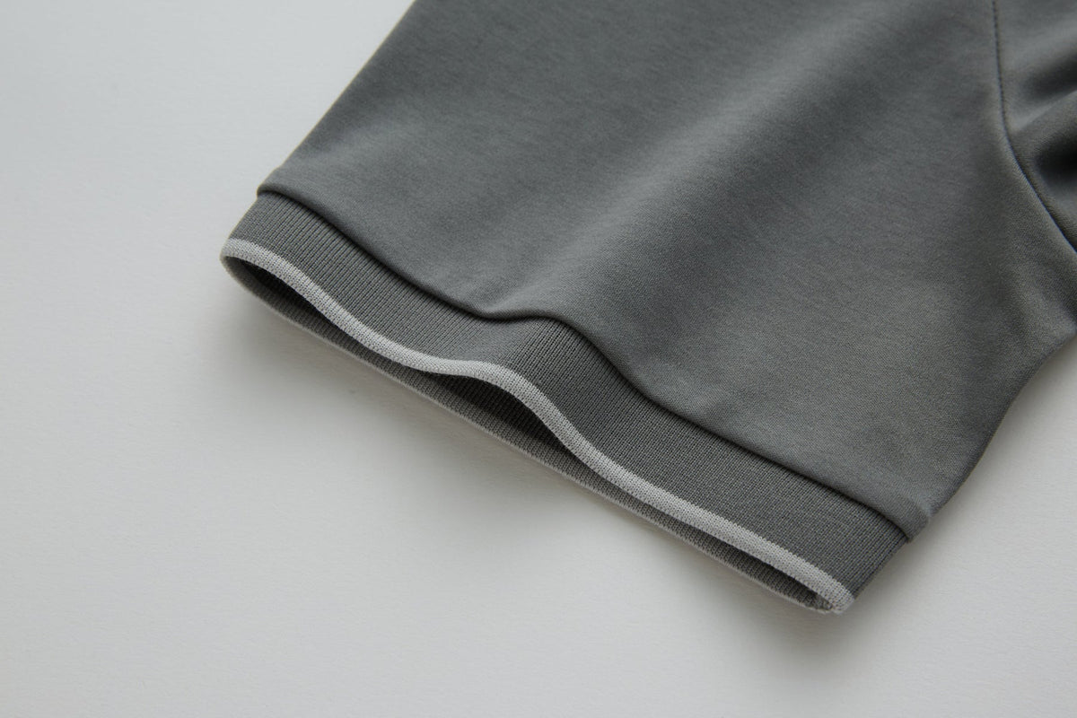 Close-up of the 6th Sense Astound December Polo in December, showing the ribbed sleeve cuff with a light stripe detail and the edge of the side seam.