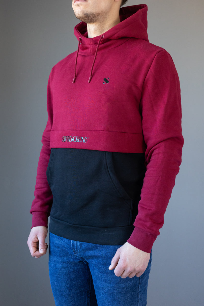 Person wearing a red and black hoodie with visible branding on a gray background