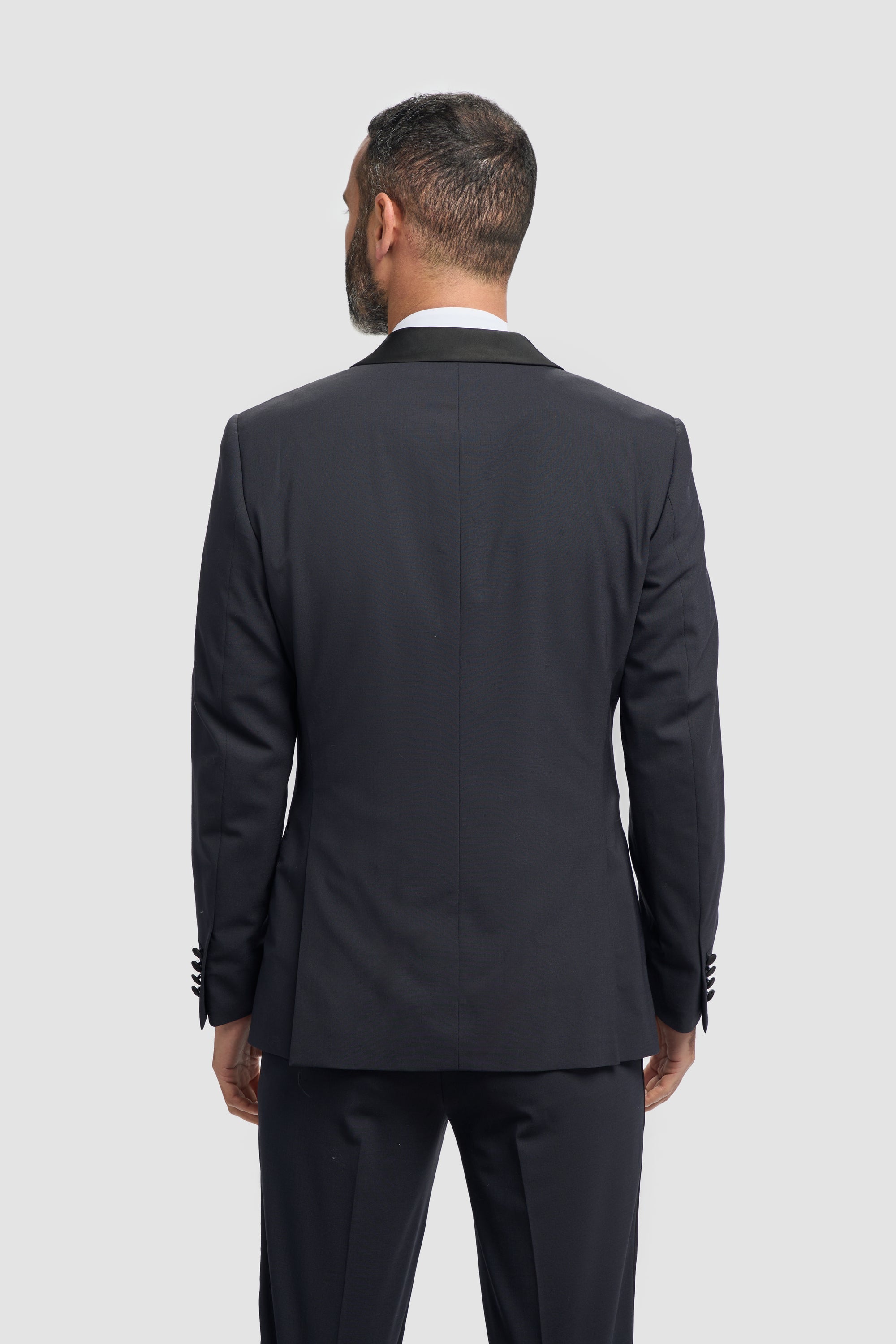 Close-up of a dark navy tuxedo jacket with a white shirt underneath.
