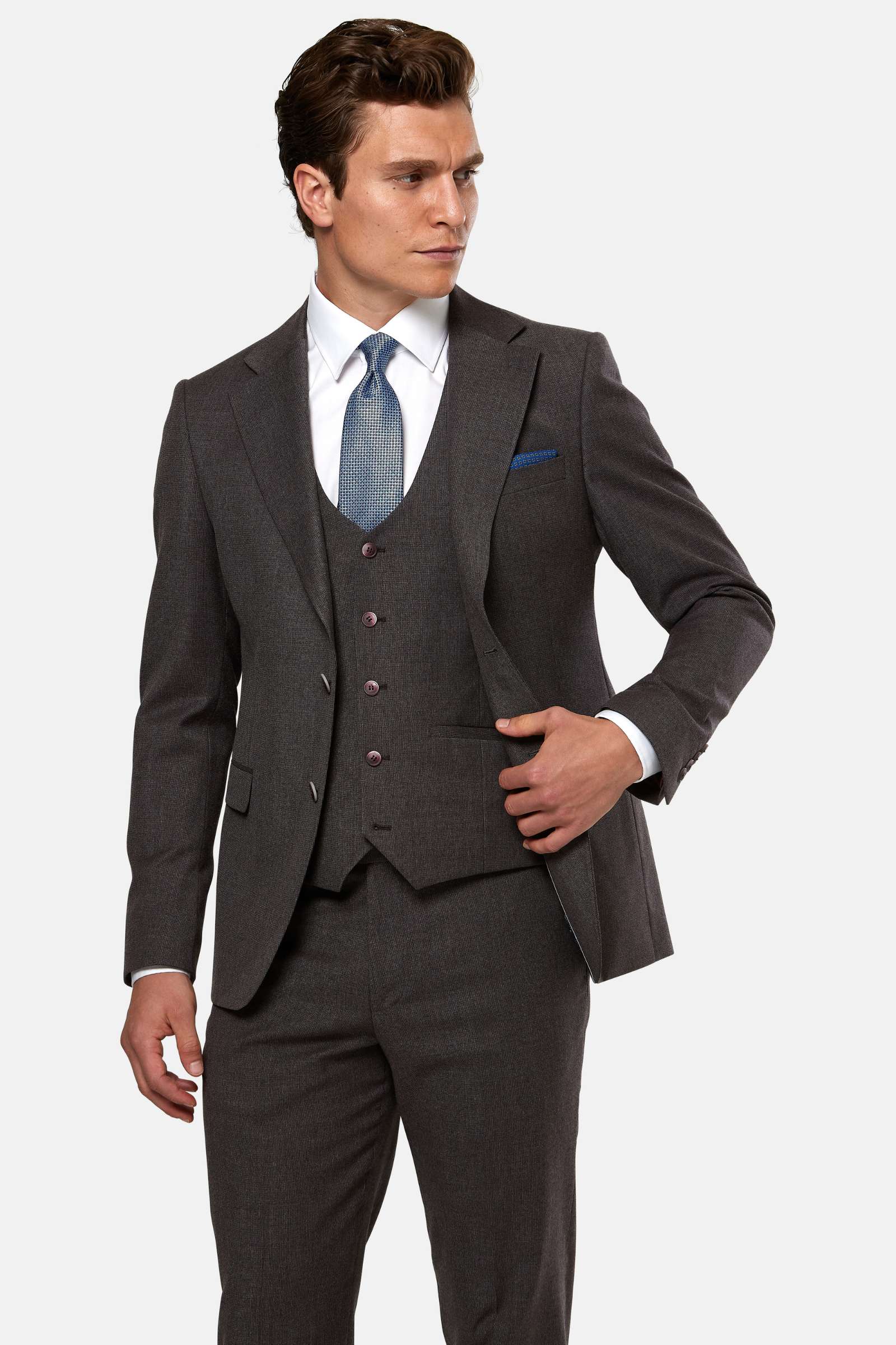 Man wearing a burgundy suit with a white shirt and blue tie on a white background