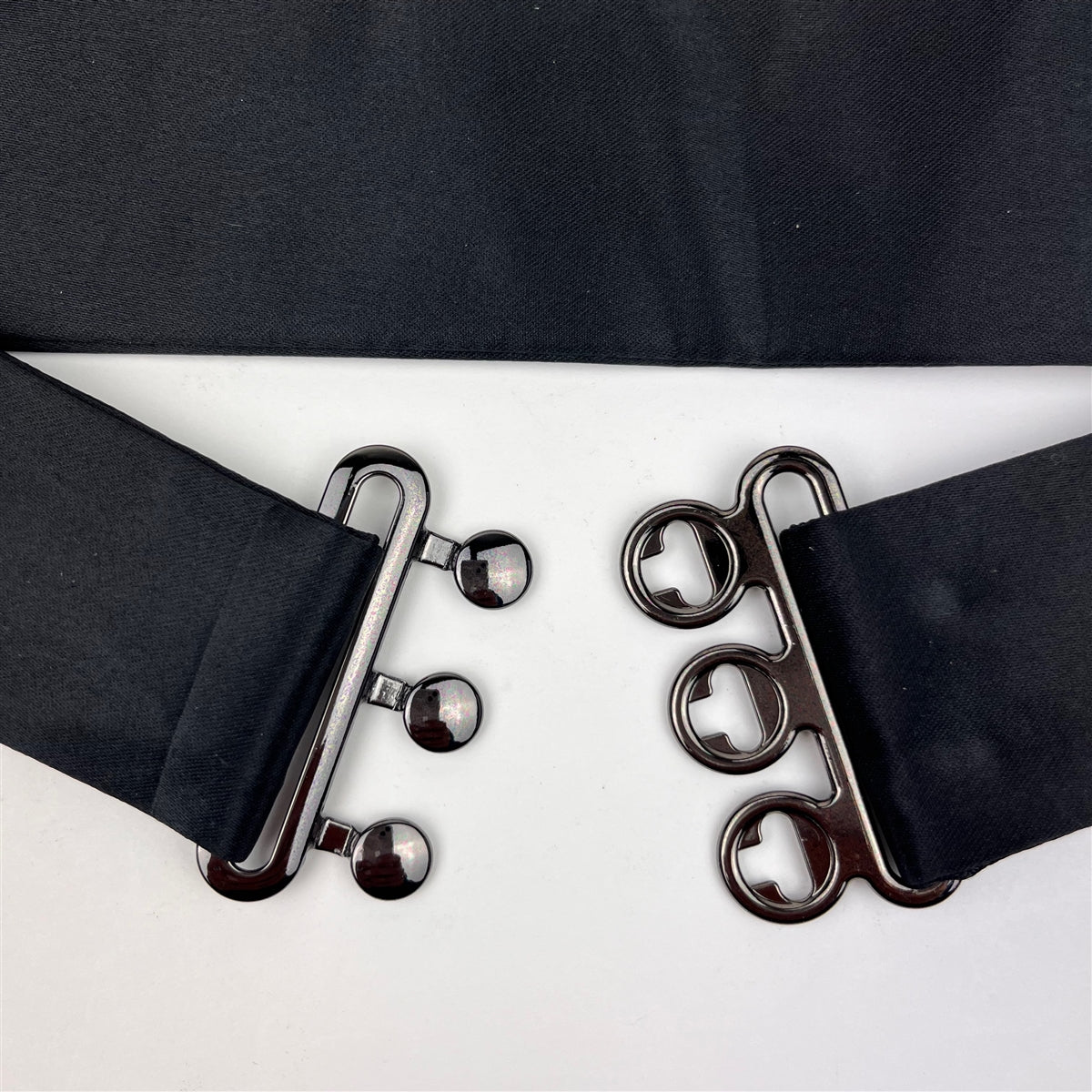 detailed close-up of a black satin cummerbund clips