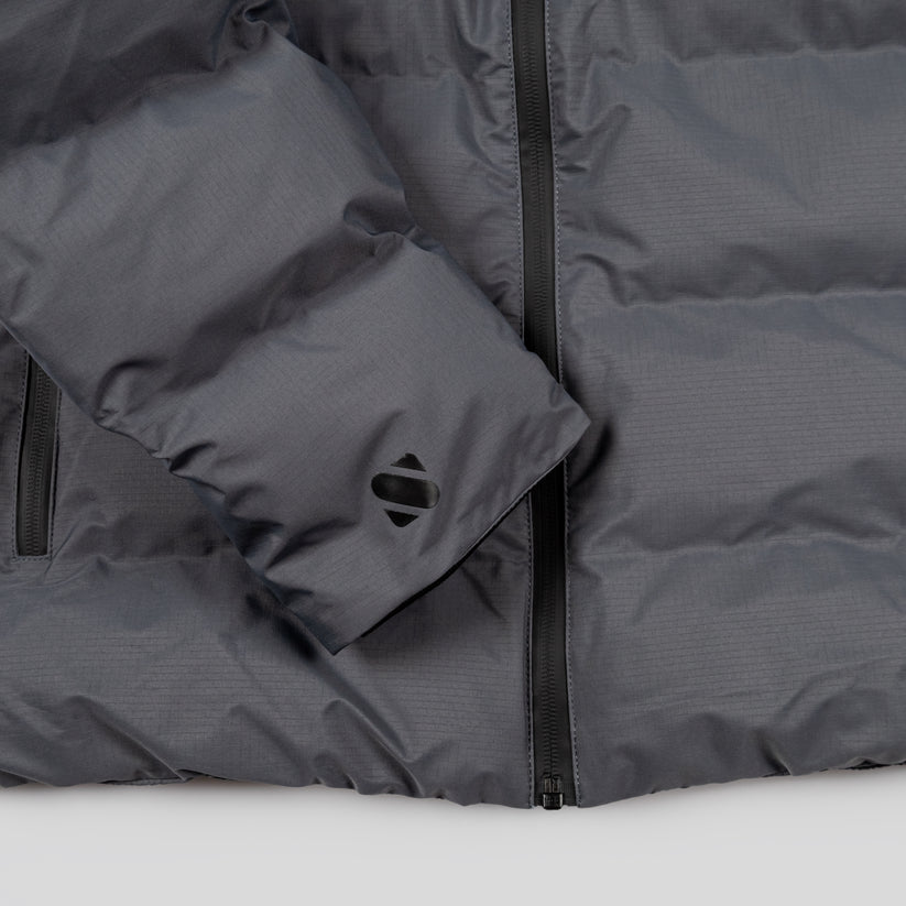 Close-up of a gray puffer jacket with a zipper on a white background