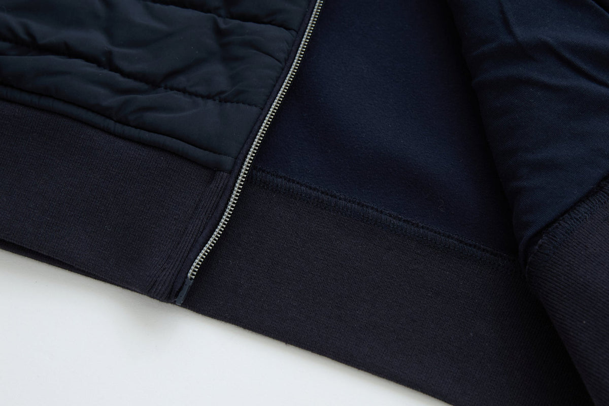 6th Sense Cloud Hybrid Full Zip Navy Jacket lower front hem showing silver zip, quilted panel and ribbed hem