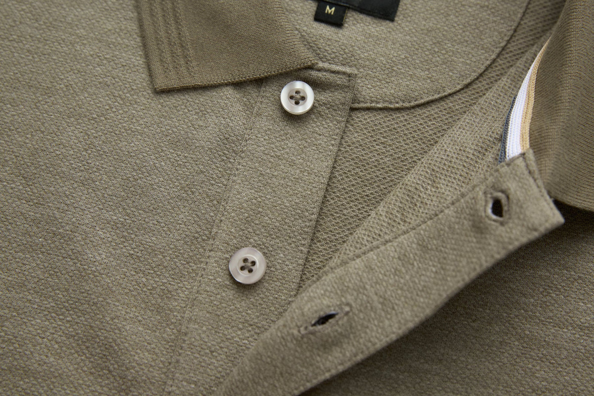 Close-up of 6th Sense Evoke Brindle Polo in brindle showing two buttons on the placket and inner neck tape.