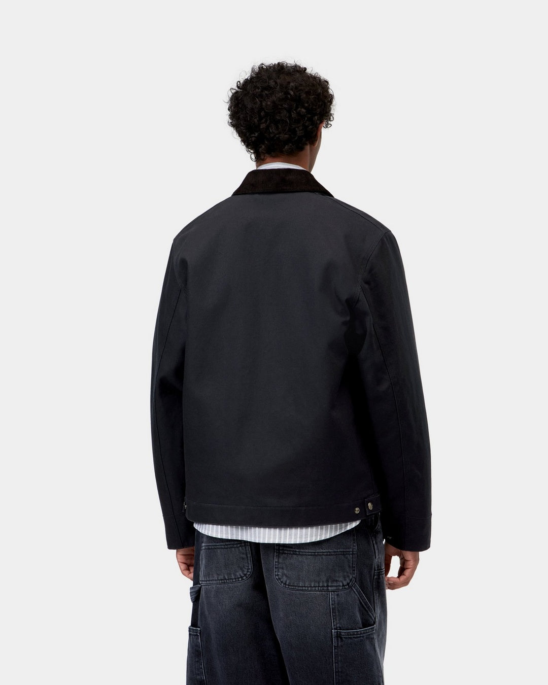 Carhartt WIP Detroit Jacket (Winter) in Dark Navy / Black, back view, showing the corduroy collar and dark jacket with a straight hem, shown on model.
