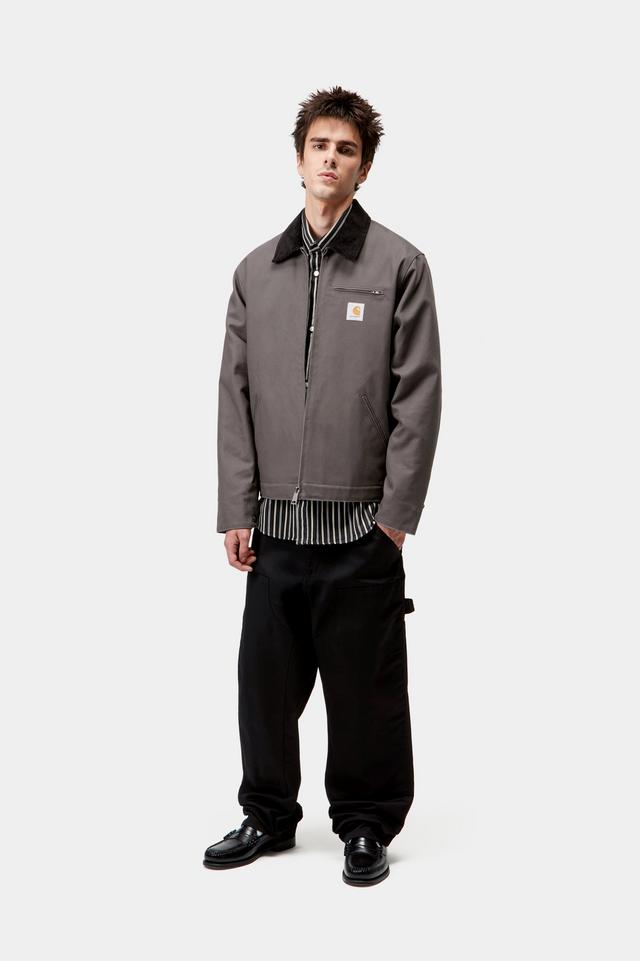 Man wearing a gray jacket with a brand logo on a white background