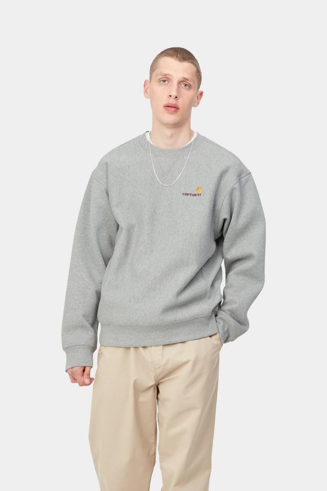 Person wearing a gray sweater with a brand logo on a white background