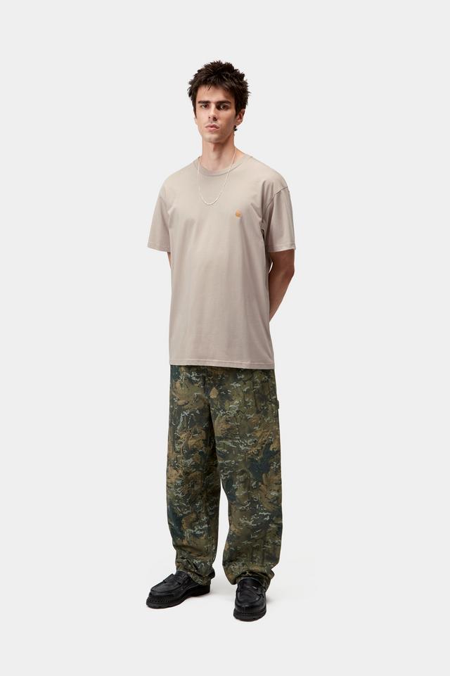 Person wearing a beige t-shirt and camouflage pants on a white background