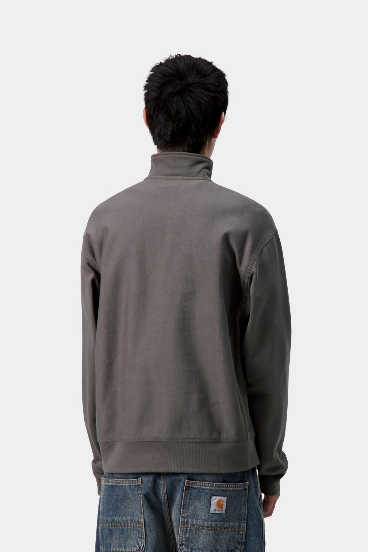 Person wearing a gray sweatshirt with a visible brand logo on a white background