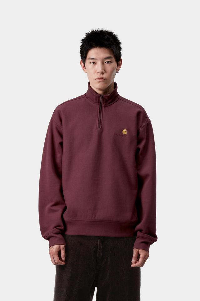 Person wearing a maroon pullover with a logo on a white background