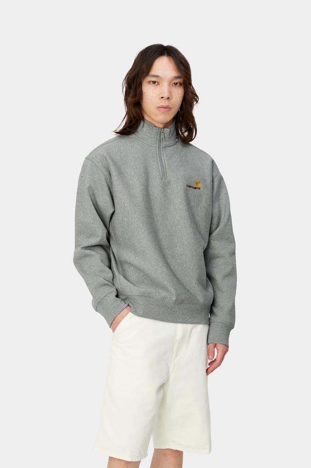 Person wearing a gray sweatshirt with a logo on a white background