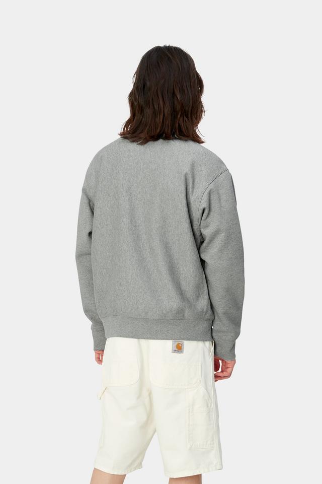 Person wearing a gray sweatshirt and white pants on a light gray background