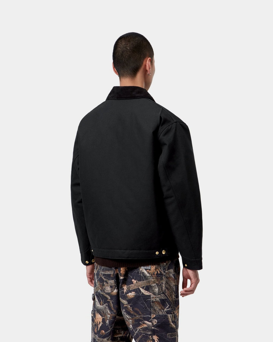 Carhartt WIP OG Detroit Jacket in Black / Black, back view, with corduroy collar and snap-adjustable hem, shown on model.