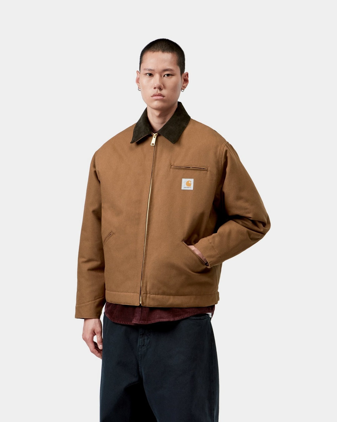 Carhartt WIP OG Detroit Jacket in WIP H Brown / Tobacco, front view on model with dark corduroy collar, zip front, chest pocket and logo patch.
