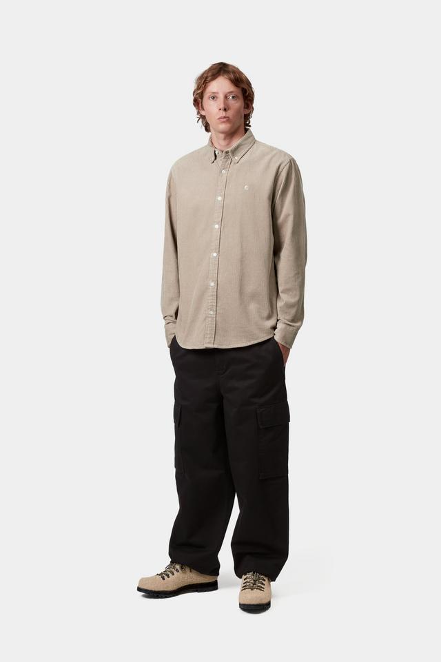 Man wearing a beige shirt and black pants on a white background