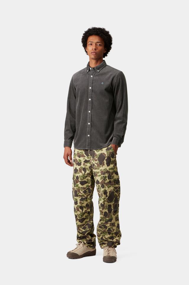 Man wearing a dark gray corduroy button-up shirt and camouflage pants on a white background