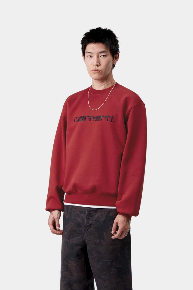 Person wearing a red Carhartt sweatshirt on a white background