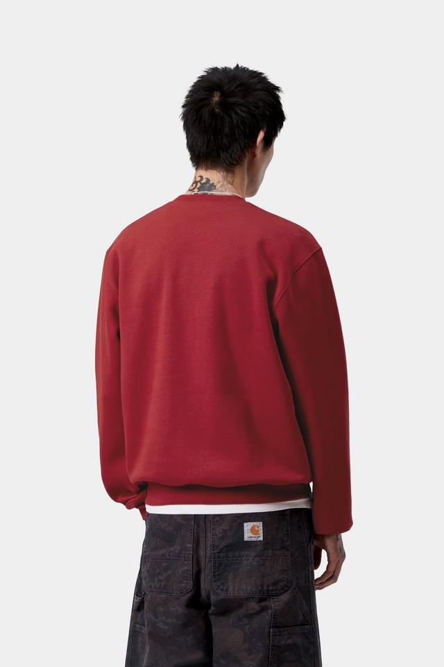 Person wearing a red sweatshirt and dark pants on a white background