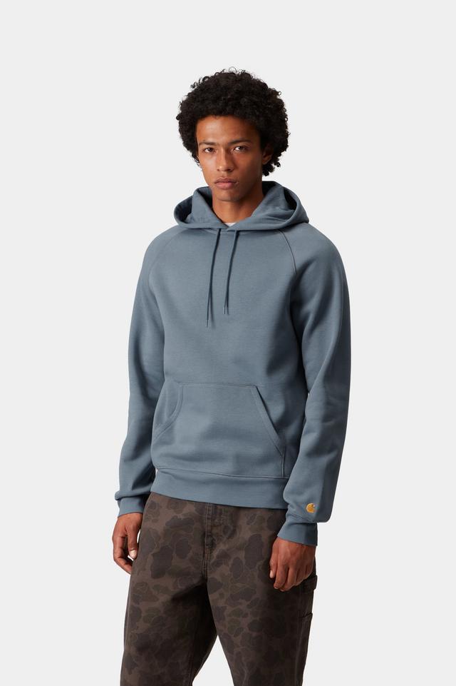 Person wearing a blue hoodie with a brand logo on a white background