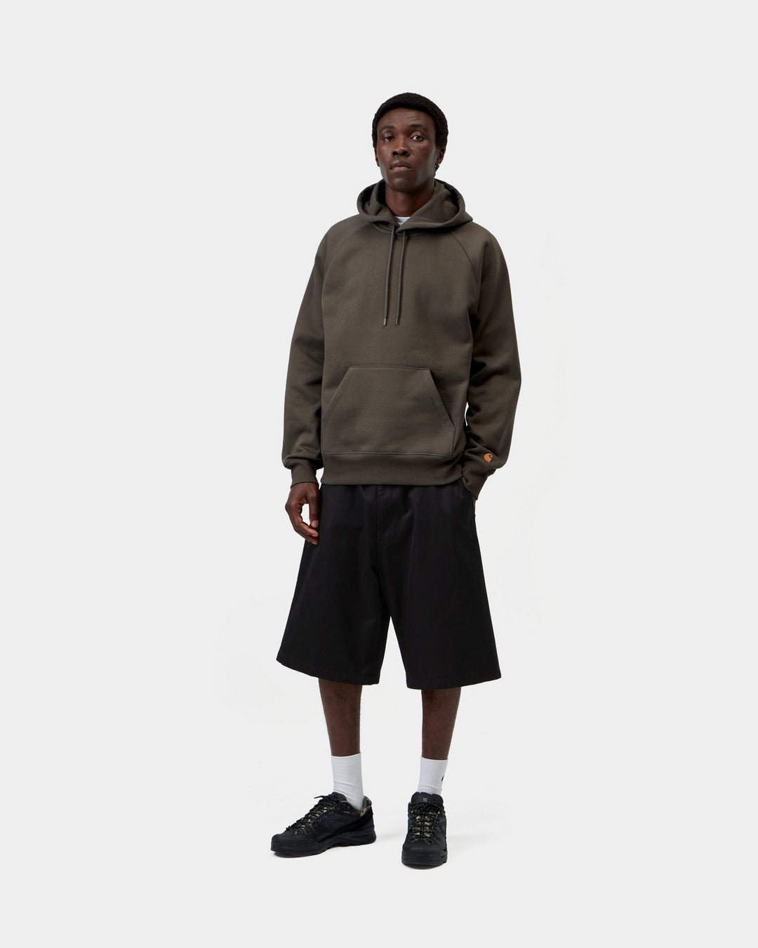 Carhartt WIP Hooded Chase Sweatshirt in Shungite / Gold, shown on a model with front view, hood, kangaroo pocket and embroidered C logo on the sleeve visible.