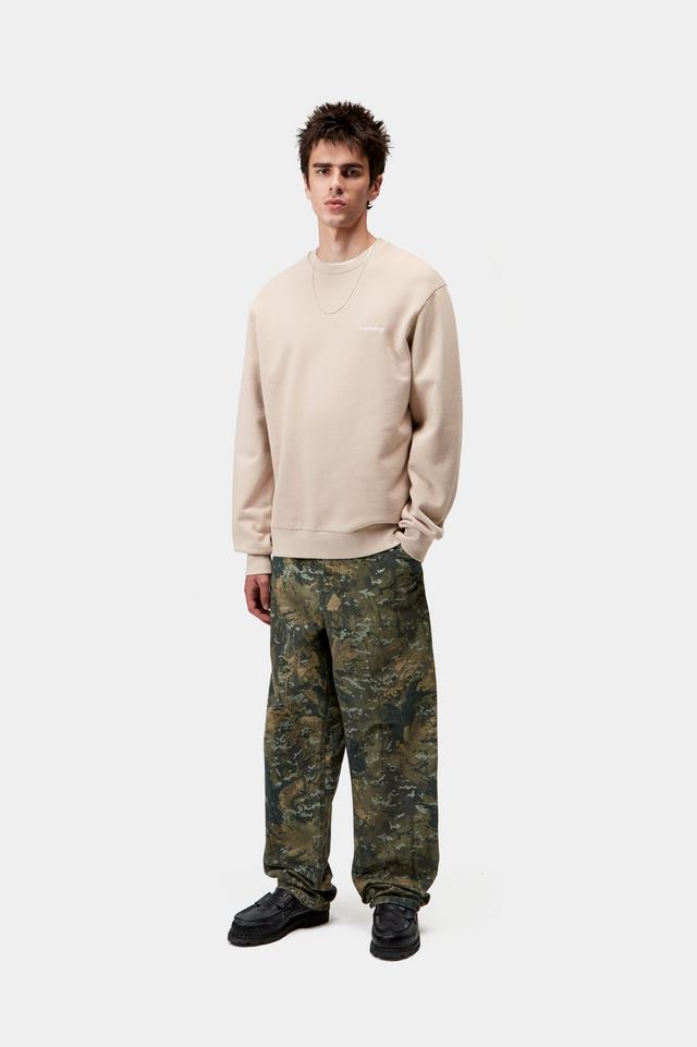 Person wearing a beige sweatshirt and camouflage pants on a white background