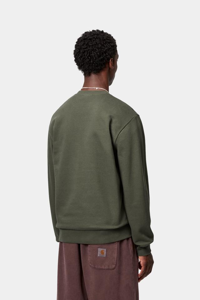 Person wearing a green sweatshirt and brown pants on a white background