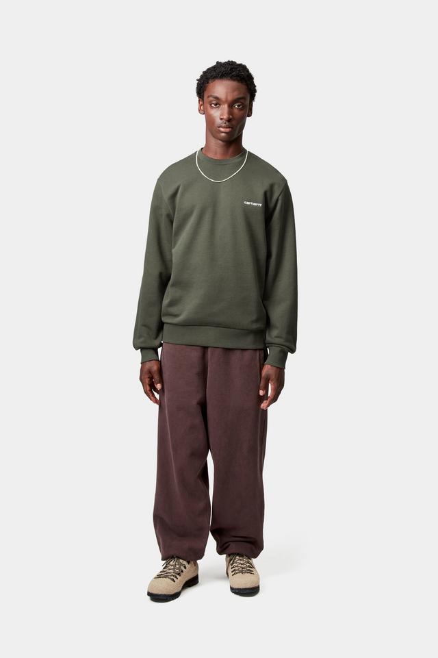 Person wearing a green sweatshirt and brown pants on a white background