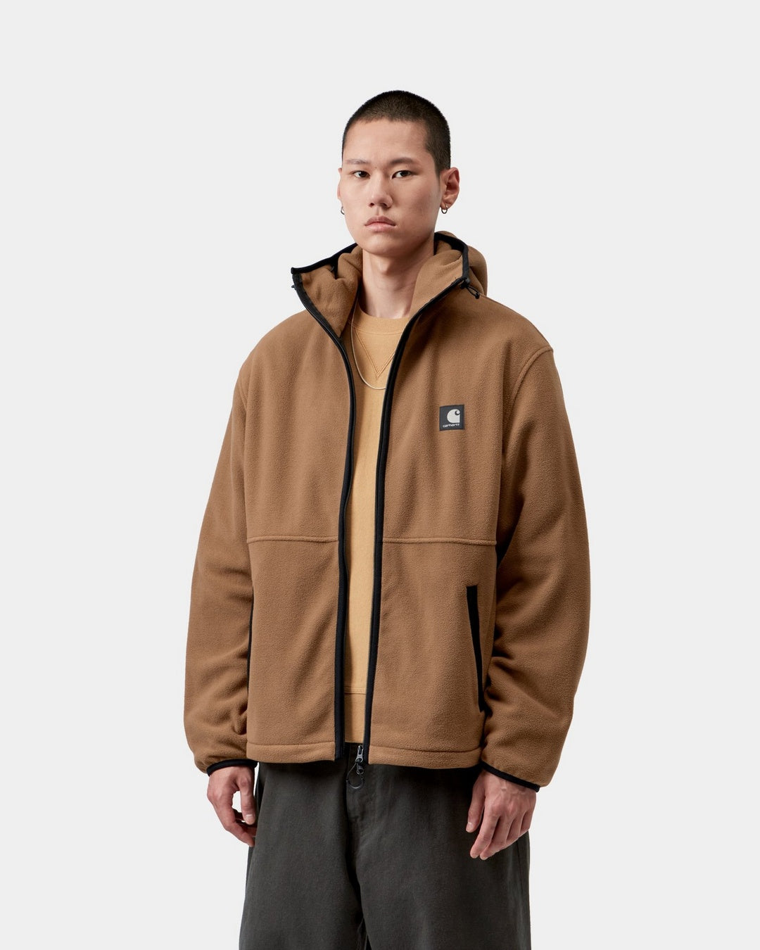 Carhartt WIP Blevin Liner in WIP H Brown, front view, with hood and reflective Square Label, shown on model.