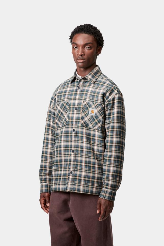 Man wearing a plaid shirt with a visible brand logo on a white background